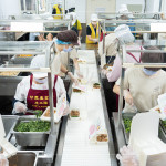 新業(yè)同仁與甘霖志工們分工合作，以生產(chǎn)線的方式有序地進行，將熱騰騰的餐食迅速裝盒，確保長輩能準時享用午餐。